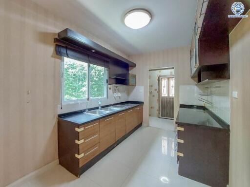 Modern kitchen with wooden cabinets and large window