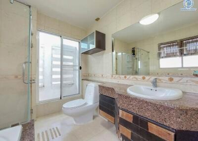 Modern bathroom with glass shower, toilet, and sink