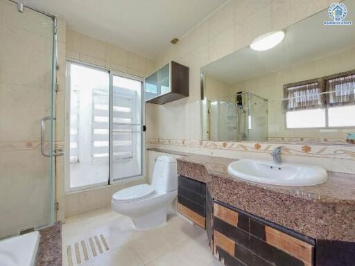 Modern bathroom with glass shower, toilet, and sink