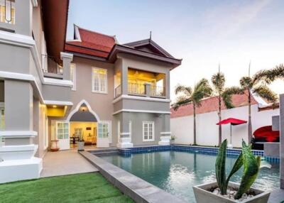 Spacious luxury house with a swimming pool at sunset