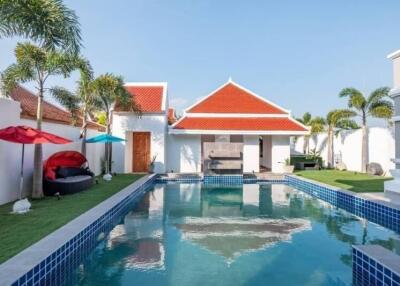 Luxury swimming pool with lounge area and palm trees