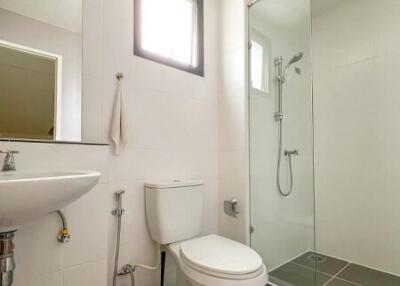 Modern bathroom with toilet, sink, and glass shower