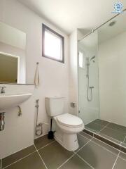 Modern bathroom with toilet, sink, and glass shower