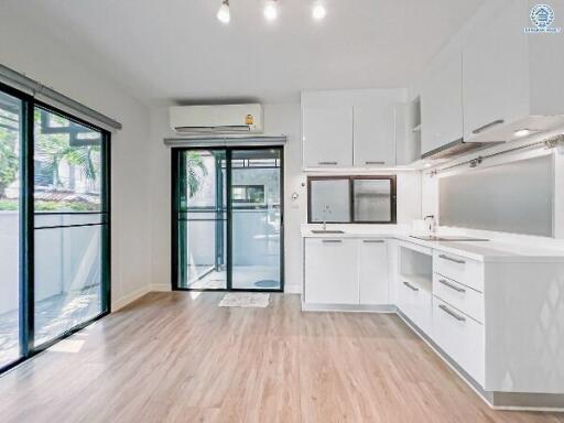 Modern kitchen with white cabinetry and large windows