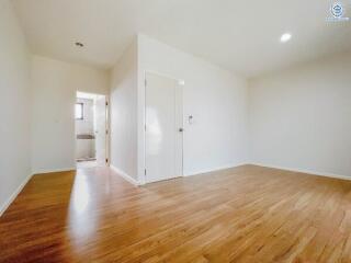 Spacious bedroom with hardwood floors and natural light