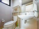 Modern bathroom with white fixtures and shelving