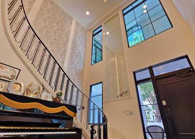 Spacious foyer with a grand staircase and chandelier