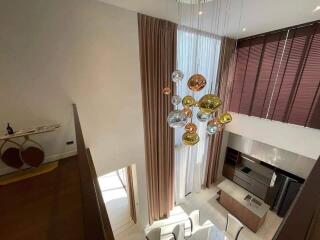 Modern living and dining area with high ceiling and contemporary chandelier