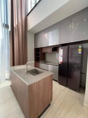 Modern kitchen with island, cabinets, and refrigerator