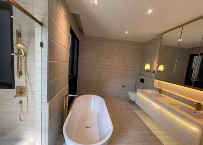 Modern bathroom with bathtub, shower, double sink vanity, and toilet