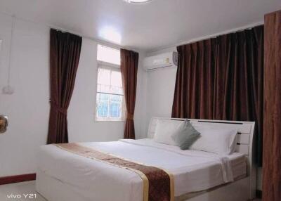 Spacious and well-decorated bedroom with double bed and curtains