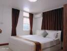 Spacious and well-decorated bedroom with double bed and curtains