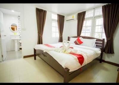 Spacious bedroom with a double bed, decorative swan towels, and attached bathroom