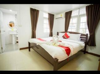 Spacious bedroom with a double bed, decorative swan towels, and attached bathroom