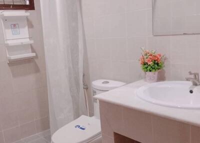 A clean and modern bathroom with a shower curtain, sink, and toilet