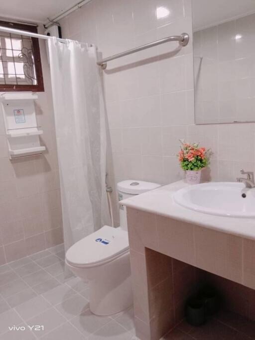 A clean and modern bathroom with a shower curtain, sink, and toilet