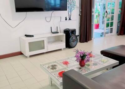 Living room with modern TV setup and glass coffee table