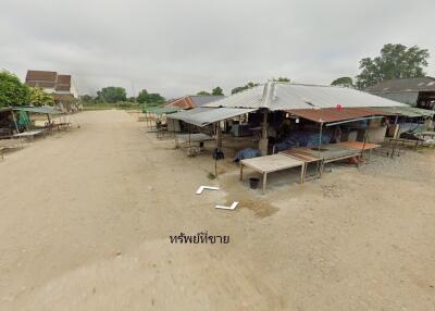 Outdoor market with multiple stalls covered by metal roofs