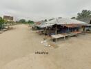 Outdoor market with multiple stalls covered by metal roofs