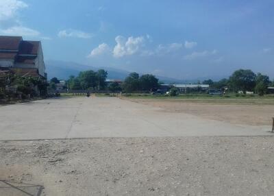 Open outdoor area with a partially visible building and mountains in the background