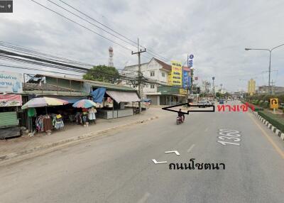 Street view with shops, vehicles, and electrical wires