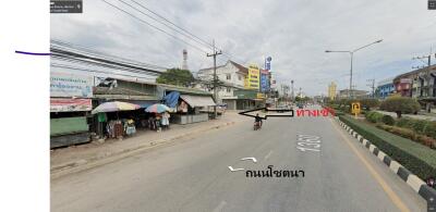 Street view with shops, vehicles, and electrical wires