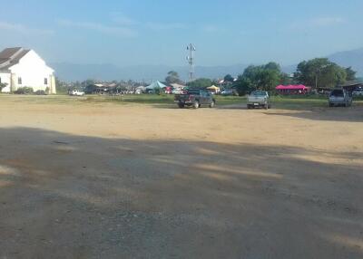 Open area with parked cars and buildings in the background