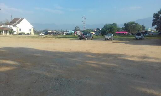 Open area with parked cars and buildings in the background