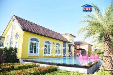 Beautiful yellow modern single-family house with a pool and garden.