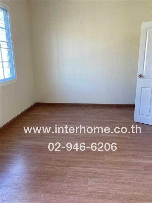 empty bedroom with wooden flooring and a window