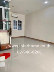 vacant living room with tiled flooring and glass shelving unit