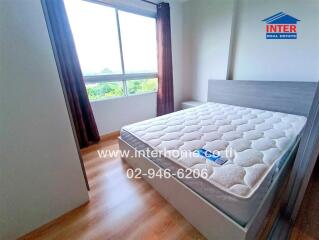 Bedroom with large window and wooden floor