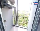 Balcony with an air conditioning unit and view of greenery