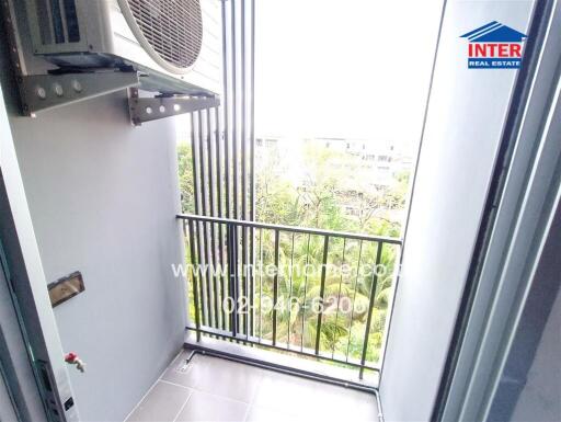 Balcony with an air conditioning unit and view of greenery