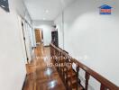 Well-lit hallway with wooden floors and railing