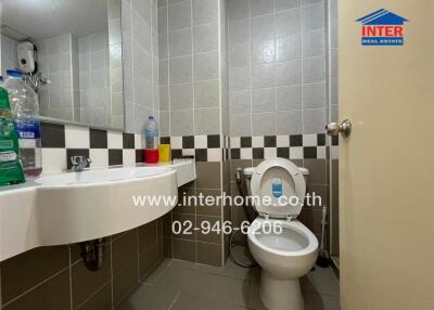 Bathroom with sink, toilet, and wall mirror