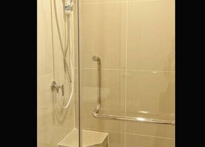 Modern shower area with glass door and amenities