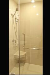 Modern shower area with glass door and amenities