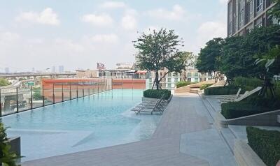 Outdoor pool area with lounge chairs and a city view