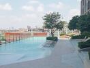 Outdoor pool area with lounge chairs and a city view