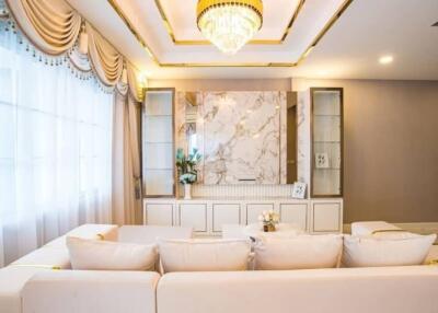 Elegant and sophisticated living room with a marble accent wall and chandelier