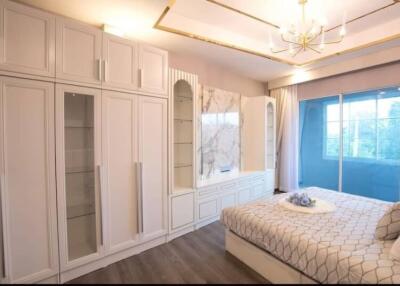 Spacious modern bedroom with large wardrobe and comfortable bed