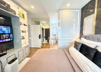 Modern bedroom with open wardrobe and ensuite bathroom