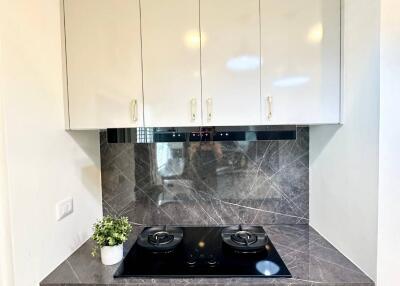 Compact modern kitchen with white cabinets and grey countertops