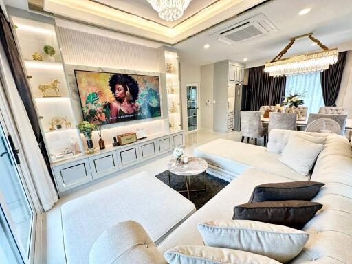 Elegant living room with modern decor, large sectional sofa, and wall-mounted TV