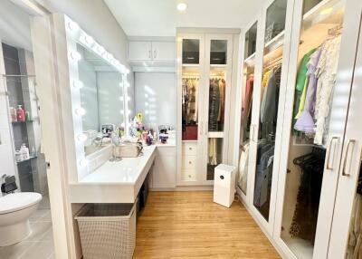 Well-organized walk-in wardrobe with vanity desk