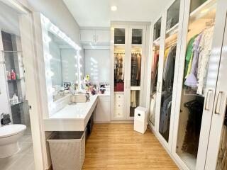 Well-organized walk-in wardrobe with vanity desk