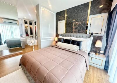 Spacious modern bedroom with large bed, walk-in closet, and stylish decor