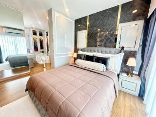 Spacious modern bedroom with large bed, walk-in closet, and stylish decor