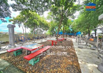 Outdoor fitness area with gym equipment and seating tables